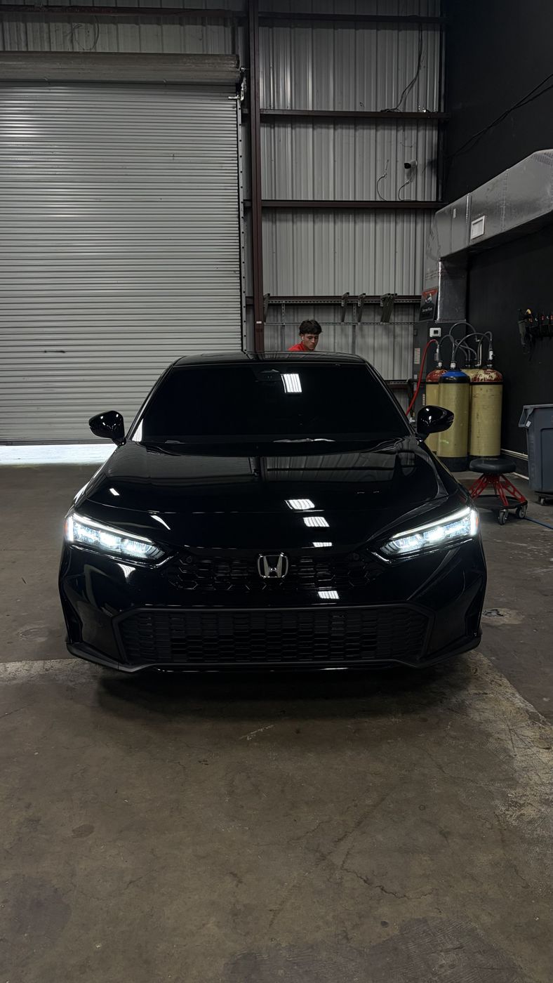 Black Honda Civic with headlights on after ceramic coating