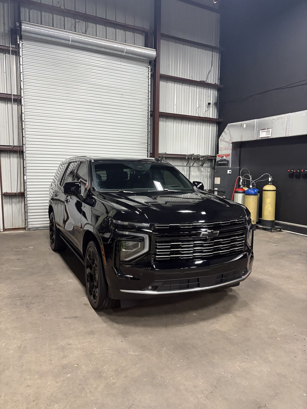Black Chevy Tahoe front three quarter view in the APES shop