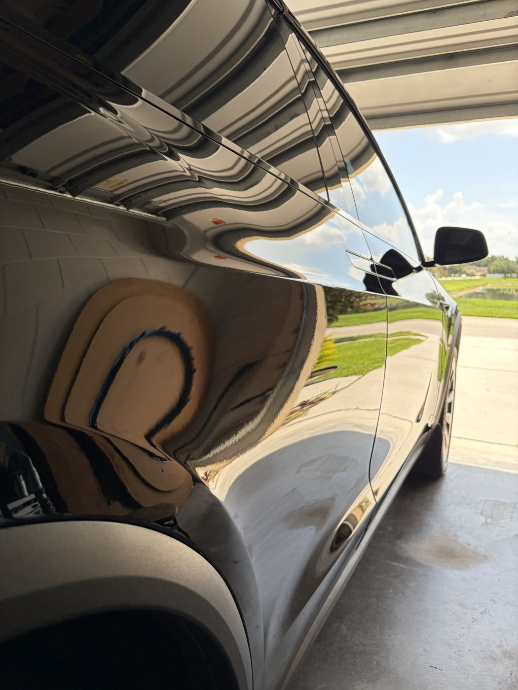 Mirror reflection on a black Tesla Model X after paint correction